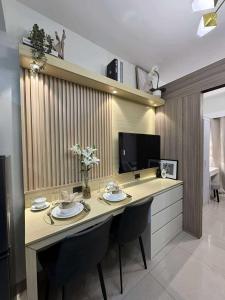 a dining room table with two chairs and a television at Blisshaven SHORE 2 B03-14100 in Sampong