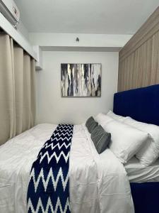 a bedroom with a large white bed with a blue headboard at Blisshaven SHORE 2 B03-14100 in Sampong +6 photos