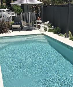 une piscine avec de l'eau bleue dans une cour dans l'établissement Courtyard Pool Studio Private Luxe Retreat, à Coal Point