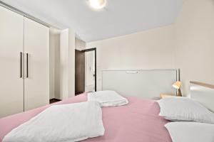 a bedroom with a pink bed with white sheets and pillows at Villa Palatium I in Fažana +50 photos