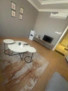 a living room with two tables and a television at غرفة وصالة الجوري 3 ابواب ذكية in Dammam