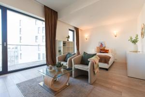 a living room with a bed and a glass table at Premium Studio Apartment in Herastrau with City View in Herăstrău