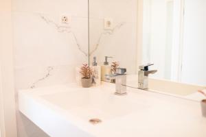 a white bathroom with a sink and a mirror at Premium Studio Apartment in Herastrau with City View in Herăstrău