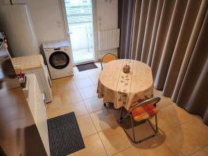a small kitchen with a table and a washing machine at Gite - Chambre d'hôtes indépendante avec Terrasse L'OCCITANIA 60m2 in Saint-Ambroix