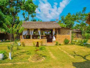 a house with a grass yard in front of it at Le Relais de Djangoa in Djangoa