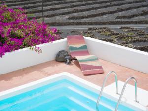 Una silla y una toalla sentadas junto a una piscina. en Casa MaVi - Vineyard with heated pool, en La Vegueta