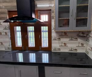 Una cocina con gabinetes blancos y una encimera negra. en Stay Enjoy, en Jāmb