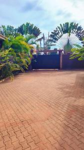 a brick courtyard with palm trees and a building at Greg j & m suites in Kira
