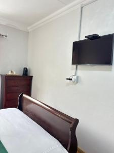 a bedroom with a bed and a flat screen tv on the wall at Creekside Guest House Middelburg in Middelburg +119 photos