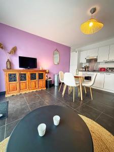a living room with a table and a kitchen at Beauregard in La Rochelle