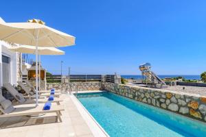 une piscine avec des chaises longues et un parasol sur un bâtiment dans l'établissement Villa Amethyst Gem by Villa Plus, à Gennadi