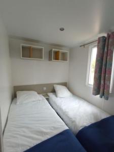 a small room with two beds in it at Camping Le vélodrome in Albert