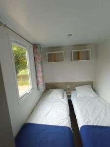 two beds in a small room with a window at Camping Le vélodrome in Albert