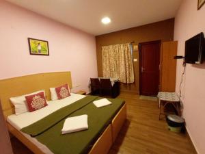 a bedroom with a large bed and a living room at B's Hive Hospitaltiy in Kodaikānāl