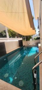 a swimming pool with an umbrella and a swimming pool at The Rajas Villa in Mattigiri