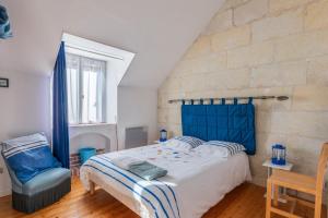 a bedroom with a blue bed and a chair at Le Petit Montparnasse - Montrichard in Montrichard