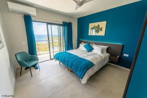ein Schlafzimmer mit blauen Wänden und einem Bett und einem Stuhl in der Unterkunft Modern Villa in Philipsburg with 450 m² and Pool in Dawn Beach