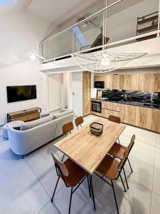 een woonkamer met een houten tafel en een bank bij Le Berlioz in La Rochelle +16 foto's