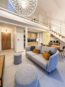 een woonkamer met een bank en een trap bij Le Berlioz in La Rochelle