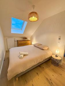 een slaapkamer met een bed met twee handdoeken erop bij Le Berlioz in La Rochelle