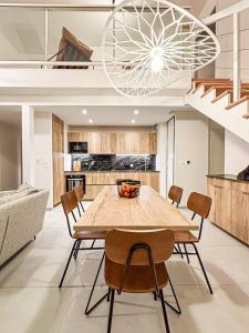 een eetkamer met een houten tafel en stoelen bij Le Berlioz in La Rochelle