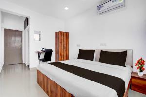 a bedroom with a large bed and a desk at Collection O Laxmi Chowk Hinjewadi in Hinjewadi