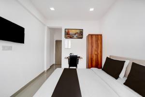 a hotel room with a bed and a desk at Collection O Laxmi Chowk Hinjewadi in Hinjewadi +23 photos