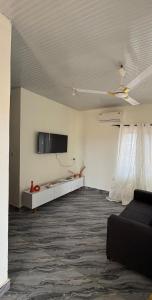 Una sala de estar con un sofá y un televisor de pantalla plana. en Kasoa Stay, en Kasoa