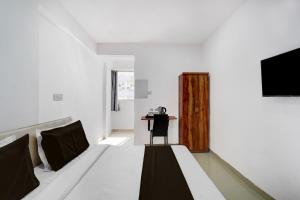 a white room with a bed and a chair at Collection O Laxmi Chowk Hinjewadi in Hinjewadi +21 photos