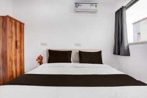a bedroom with a white bed with black pillows at Collection O Laxmi Chowk Hinjewadi in Hinjewadi
