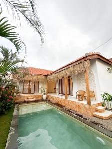 a villa with a swimming pool and a house at Momy Breeze Uluwatu in Bingin Beach