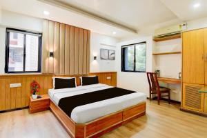 a bedroom with a bed and a desk at Super Townhouse Viman Nagar Business Stay Formerly Silver Crest in Pune