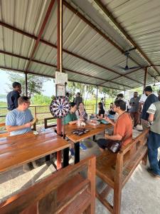 a group of people sitting at long wooden tables at ShivaRewa Village stay in Maheshwar