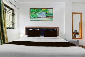 a bedroom with a bed and a painting on the wall at Collection O Candolim Beach Formerly Poornima Place in Candolim +21 photos