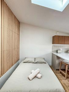 Un dormitorio con una cama con dos toallas encima. en La Cahute Rochelaise - Cosy dans le centre-ville à 5 min du port, en La Rochelle