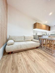 Una sala de estar con un sofá y una cocina. en La Cahute Rochelaise - Cosy dans le centre-ville à 5 min du port, en La Rochelle