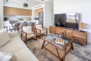 a living room with a large flat screen tv at Frank Porter - Parkside 2, Emaar South in Ghantoot