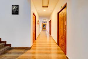 - un couloir avec des portes en bois et du parquet dans l'établissement Super Townhouse Auroville Beach Formerly De Heritage, à Kottakupam