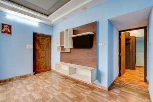a living room with blue walls and a flat screen tv at Hotel O Ashok Nagar Metro Station Chennai Formerly G Cloud in Chennai