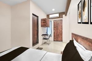 ein Schlafzimmer mit einem Bett, einem Schreibtisch und einem Stuhl in der Unterkunft Super Collection O Palampur Surat Formerly Hotel Royal Paradise in Bhatha + 22 Fotos