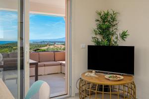 a living room with a tv and a table at Villa Leone con piscina privata in Punta Molara