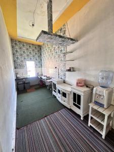 a large room with a kitchen with white appliances at Rahayu Cabin Villa in Dieng
