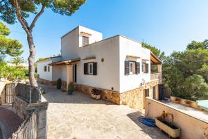 a white house with a fence and trees at Villa Escaletas in Cala Santanyi