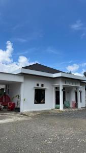 a white house with a black roof at Rahayu Cabin Villa in Dieng