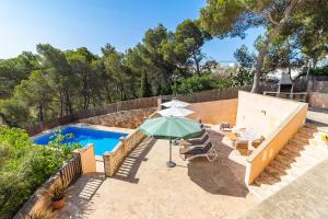 a patio with an umbrella and a swimming pool at Villa Escaletas in Cala Santanyi