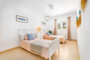 a white bedroom with a bed and a couch at Villa Escaletas in Cala Santanyi +41 photos