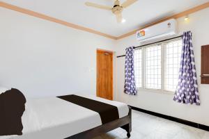 a bedroom with a bed and a window at Super Hotel O Guntur Railway Junction in Guntūr