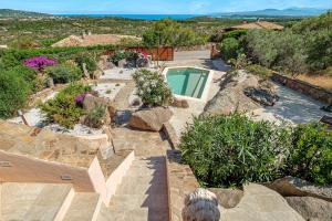 a backyard with a swimming pool and some rocks at Villa Leone con piscina privata in Punta Molara