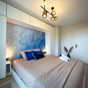 a bedroom with a large bed with a painting on the wall at Escapade Rochelaise in La Rochelle