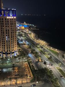 a city street at night with a tall building at Elegant apartment overlooking the sea in Jeddah